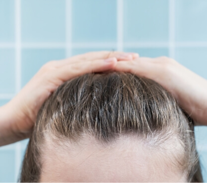 young-woman-touching-her-hair-close-up-on-blue-bac-2023-11-27-05-22-39-utc (1)